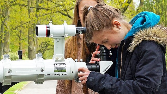 Schüler:innen an einem Teleskop